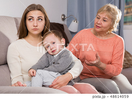 Two adult female are having disagreements with upbringing kid Two adult female are having disagreements with upbringing kid 48614059