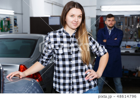 Smiling female is satisfied of tire replacement of her car in spring 48614796