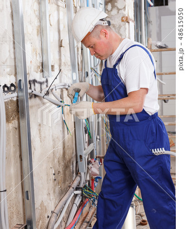 Electrician laying electric wires 48615050