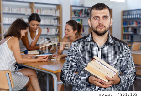 Male student with pile of books 48615105