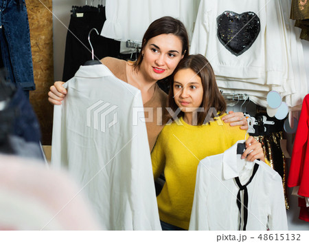 Mother and daughter choosing pretty blouse 48615132