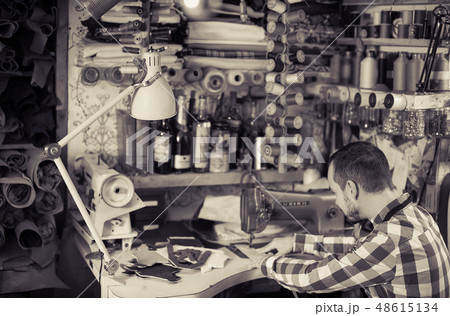 Male worker stitching new belt Male worker stitching new belt 48615134