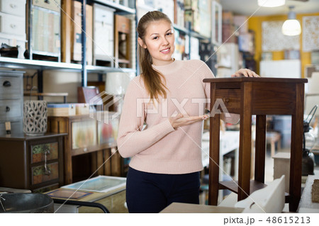 Woman buyer standing in furniture shopping room near chest of drawers 48615213