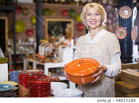 Woman customer posing with ceramic cookware Woman customer posing with ceramic cookware 48615288