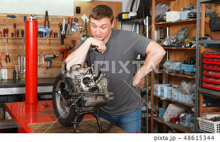 Man mechanic repairing modern moto Man mechanic repairing modern moto 48615344