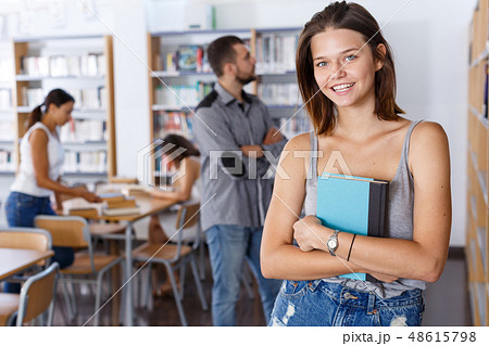 Young woman with book in library 48615798