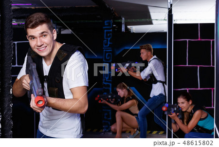 Portrait of excited guy with laser pistol playing laser tag in arena 48615802