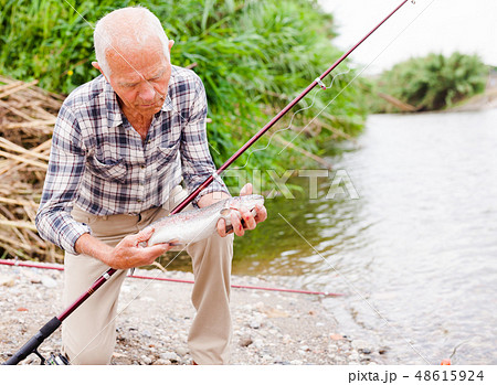 Mature fisherman examining catch 48615924