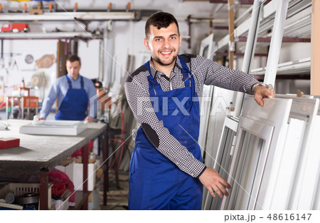 Young laborer is inspecting the window frame 48616147