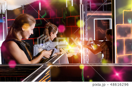 Guys and girls in vests and with laser pistols playing lasertag 48616296