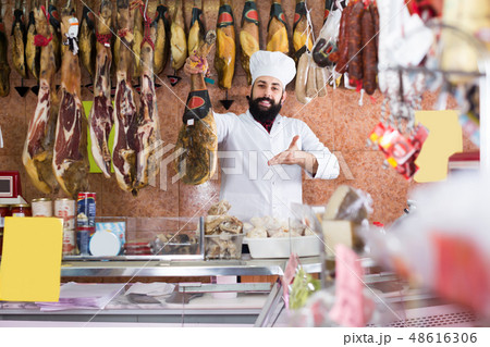 Laughing man seller showing jamon Laughing man seller showing jamon 48616306