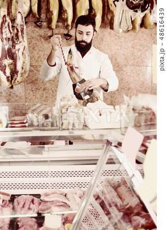 Handsome male seller showing jamon 48616439