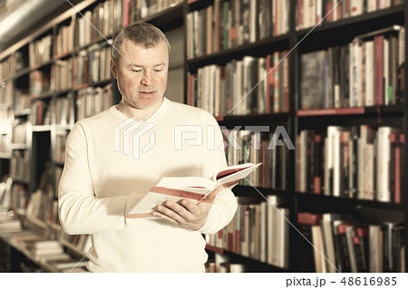 Male reading books in bookshop Male reading books in bookshop 48616985