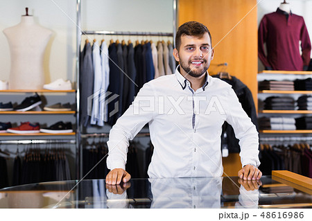 Positive young man seller in men's boutique 48616986