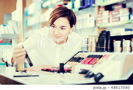 Happy female customer looking for make-up items 48617080