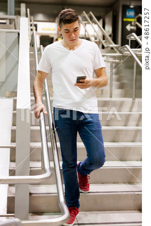 Man with phone on stairs of subway Man with phone on stairs of subway 48617257