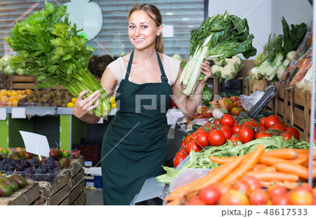 woman selling fresh greens on market . 48617533