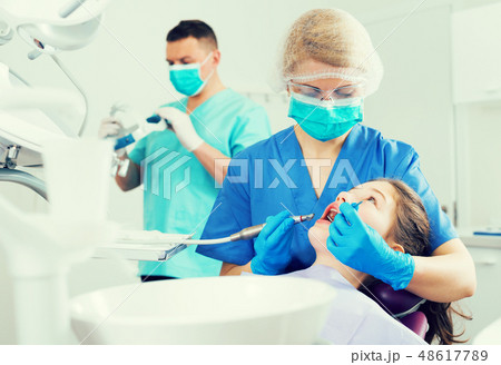 Female dentist with girl patient during oral checkup Female dentist with girl patient during oral checkup 48617789