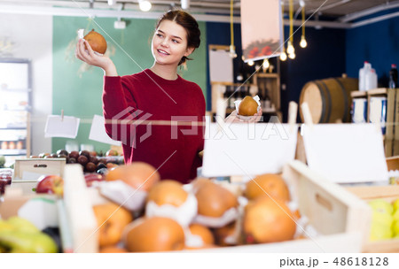 Good young girl choosing pear at market 48618128
