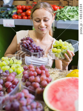 Woman customer buying sweet ripe grapes on marketplace Woman customer buying sweet ripe grapes on marketplace 48618384