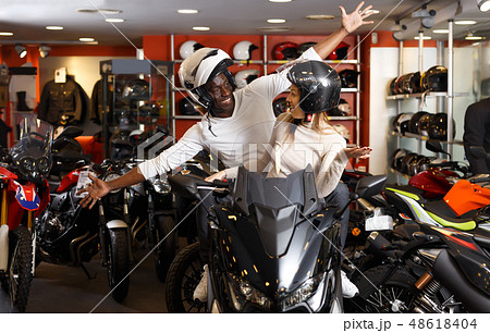 Glad young couple laughing sitting on bike 48618404