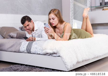 Bored couple with phones on bed 48618538