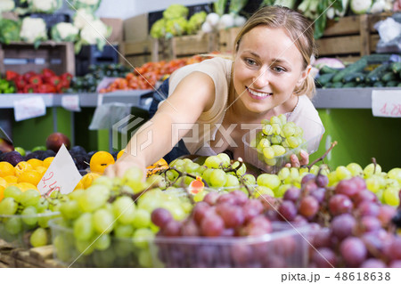 Woman customer buying sweet ripe grapes on marketplace Woman customer buying sweet ripe grapes on marketplace 48618638