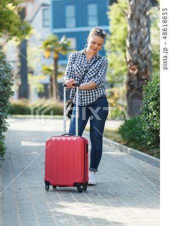 Girl walking around city with suitcase 48618655