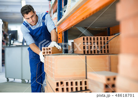 man is calculating bricks before selling man is calculating bricks before selling 48618701