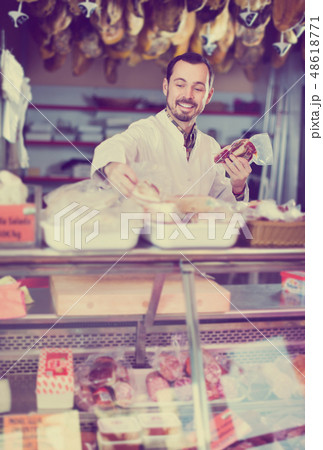 Positive male butcher showing sorts of meat 48618771