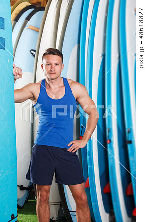 man choosing surf equipment in surf club man choosing surf equipment in surf club 48618827