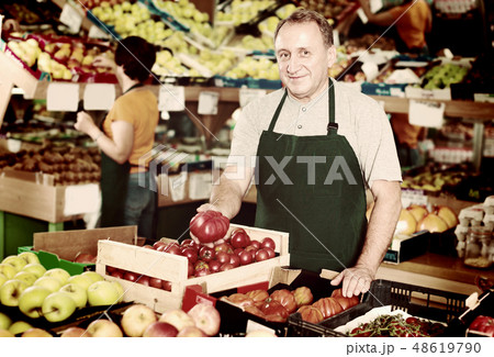 Smiling male seller is demonstrating tomatos 48619790