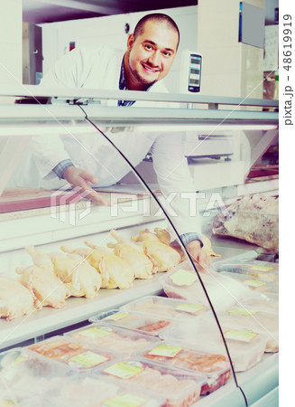 salesman near display with chicken salesman near display with chicken 48619919