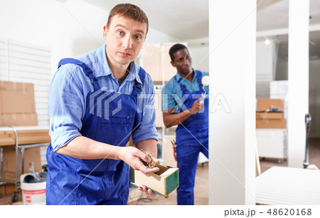 Two male builders working at indoors building site Two male builders working at indoors building site 48620168