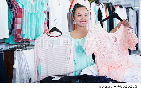 Happy young woman customer selecting new clothing 48620239