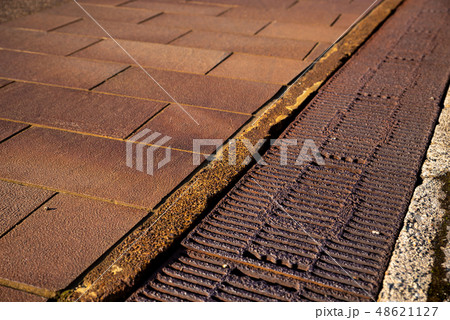 雪国の赤茶けた路面と側溝の蓋 48621127
