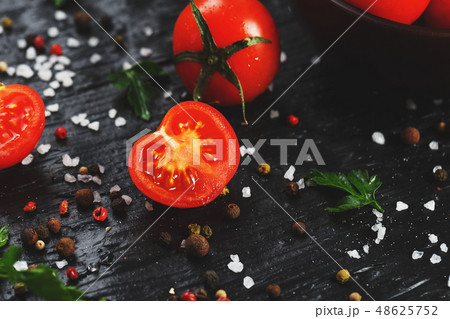 Juicy red cherry tomatoes on a black background  48625752