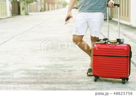 Man holding Red luggage with passport on blurred Man holding Red luggage with passport on blurred 48625756