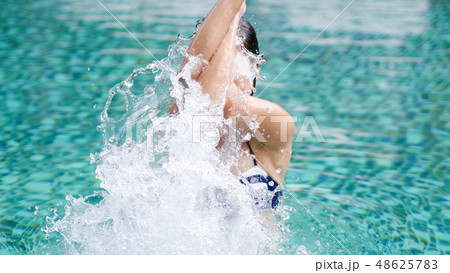 professional woman do yoga eagle pose in swim pool 48625783