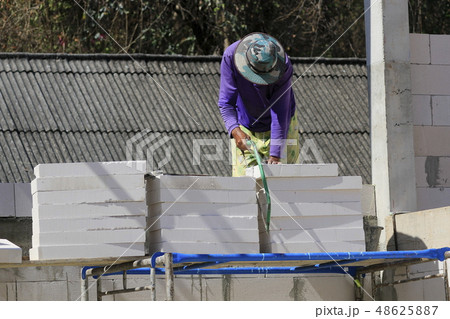 Construction technicians are building brick walls  48625887