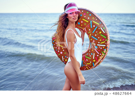 Woman in swimsuit with swim ring Woman in swimsuit with swim ring 48627664