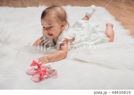 Newborn baby and a pair of baby shoes 48630819
