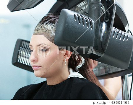 Woman in hairdresser, drying hair under machine 48631462
