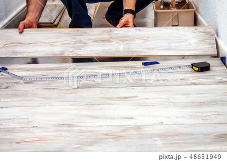 Man installing new wooden laminate flooring at home. 48631949