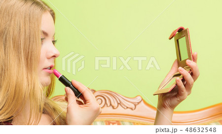 Attractive woman applying lipstick. Make up. Attractive woman applying lipstick. Make up. 48632548