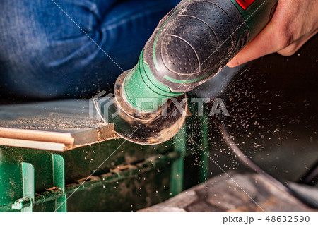 Close up of woman cutting laminate of wooden floor Close up of woman cutting laminate of wooden floor 48632590