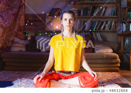 Close-up of woman's hand in yoga lotus pose meditating in a crafting room with candles 48632668