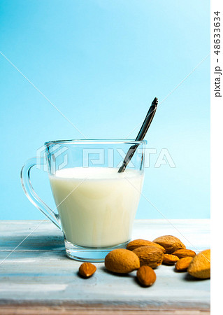 Almond milk in a glass against blue background 48633634