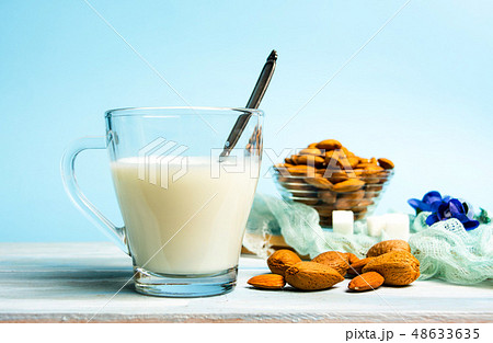 Almond milk in a glass against blue background 48633635