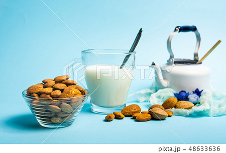 Almond milk in a glass against blue background 48633636